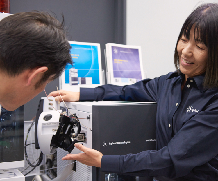 A technician demonstrating the use of scientific equipment to a colleague