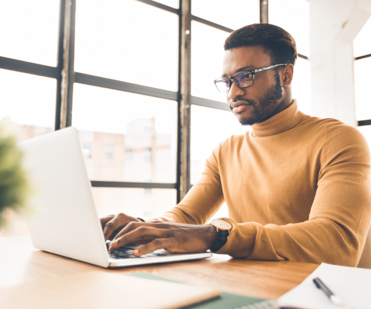 A man typing on a laptop keyboard