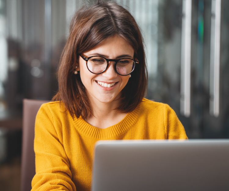 A woman smiling using a laptop