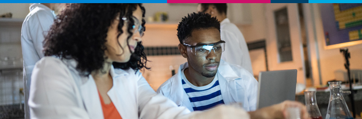 Two university students working in a lab environment.